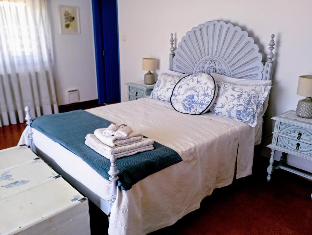 um quarto com uma cama branca com almofadas azuis e brancas em Sunset Vista apartment A em Cardigos