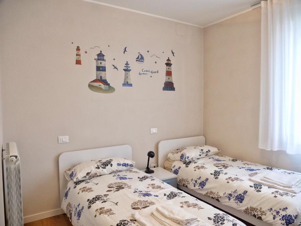 A bed or beds in a room at FARO DELL'ESTATE delizioso BICAMERA con POSTO AUTO dietro la SPIAGGIA