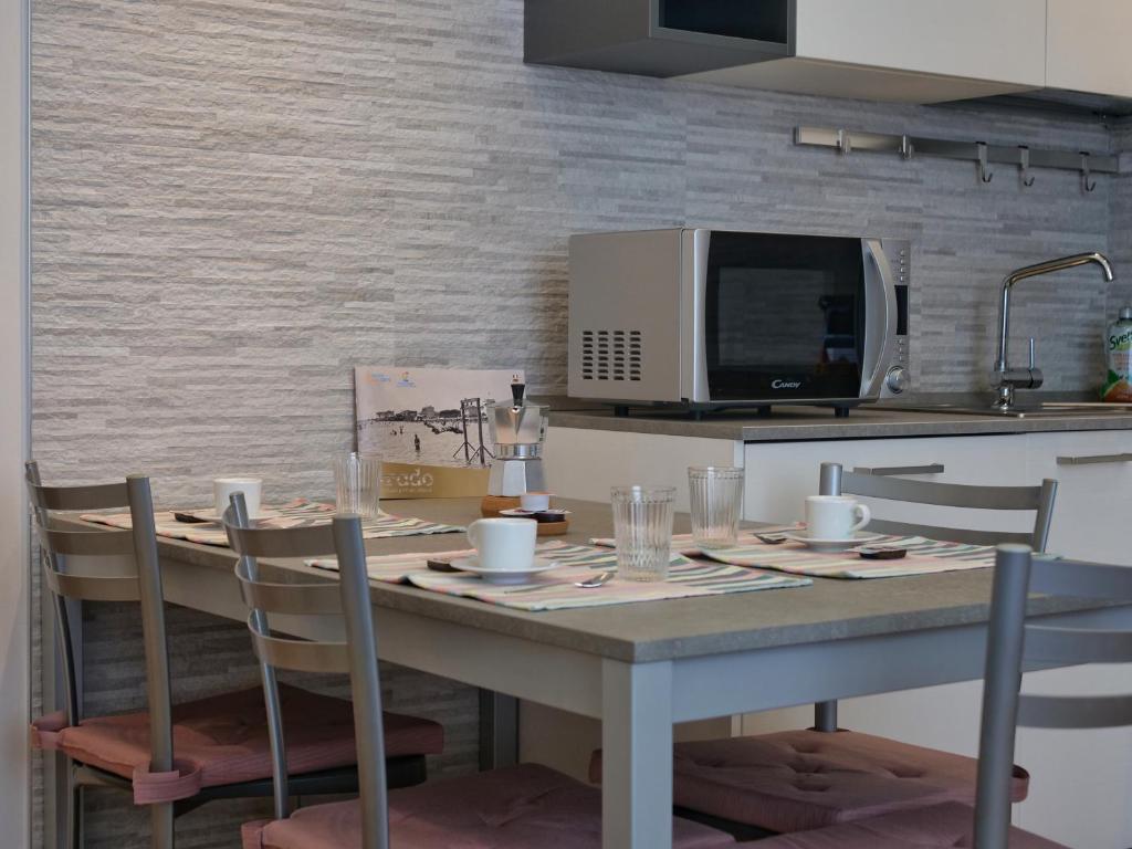 A kitchen or kitchenette at FARO DELL'ESTATE delizioso BICAMERA con POSTO AUTO dietro la SPIAGGIA