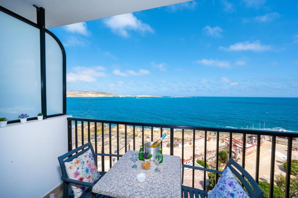 d'une table et de chaises sur un balcon donnant sur l'océan. dans l'établissement Islet Promenade Seafront 1 Bedroom Apartment with 2 seaview balconies by Getawaysmalta, à San Pawl il-Baħar