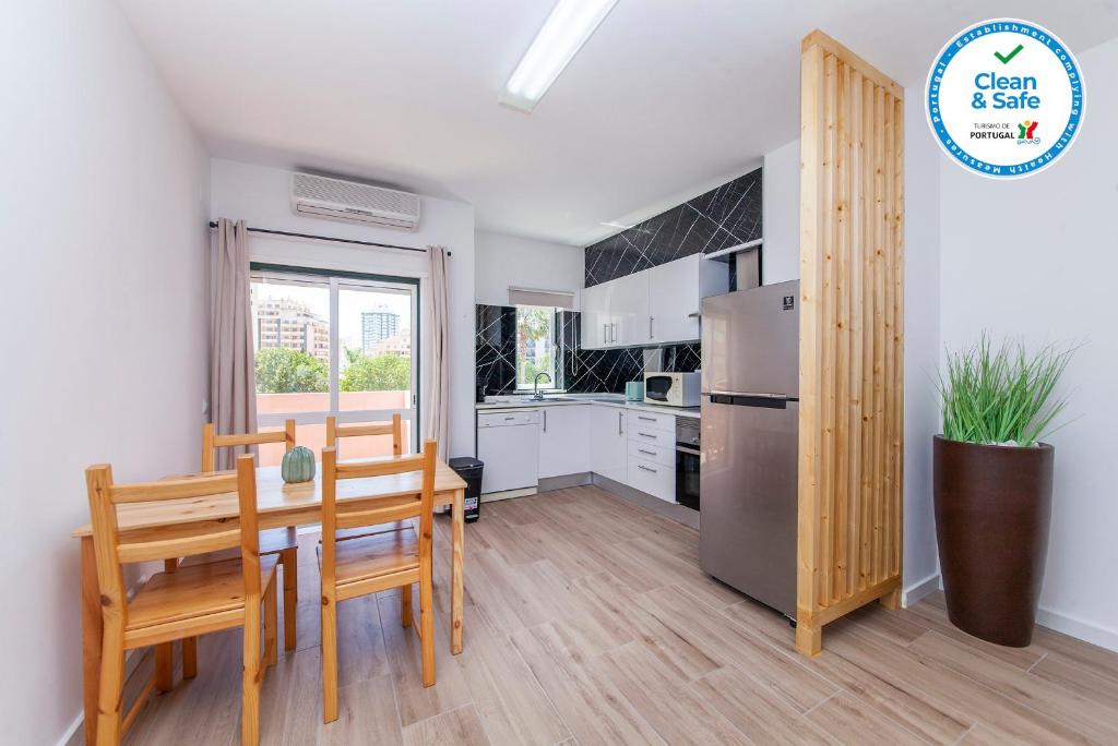 cocina con mesa, sillas y nevera en A50 - Castelos Apartment in Portimão, en Portimão