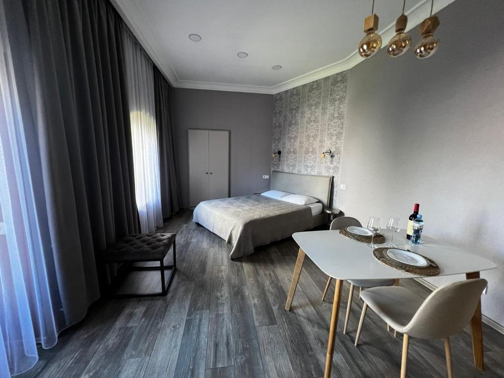 a bedroom with a bed and a table and chairs at Chikhi in Tbilisi City