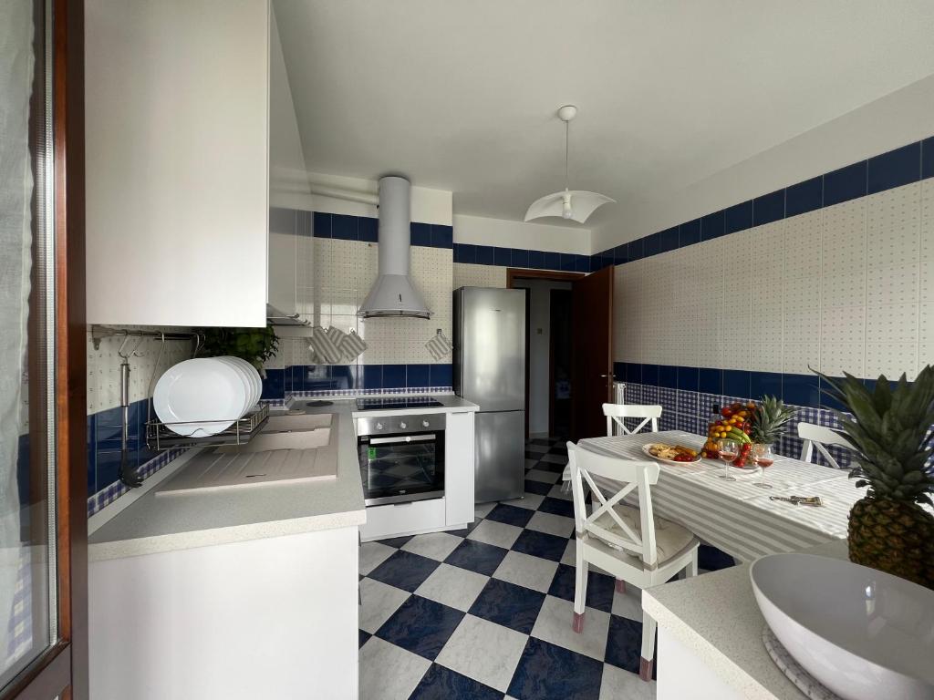 una cocina con armarios blancos y azulejos azules y blancos en Morada Azul, en Monopoli