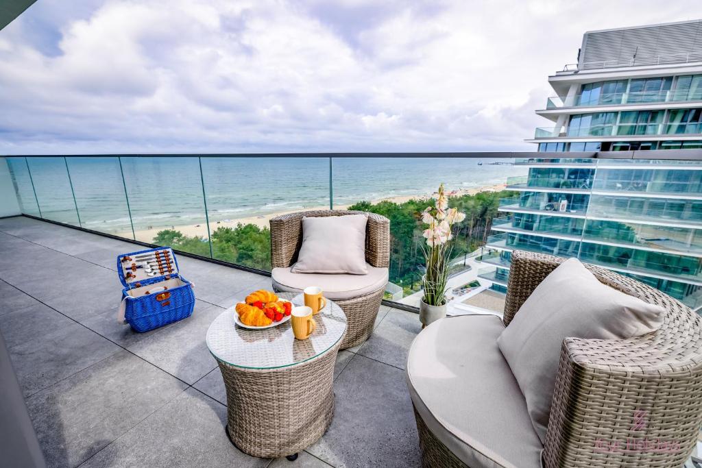 balkon z krzesłami i stołem z widokiem na ocean w obiekcie Your Holidays Waves A865 w mieście Międzyzdroje