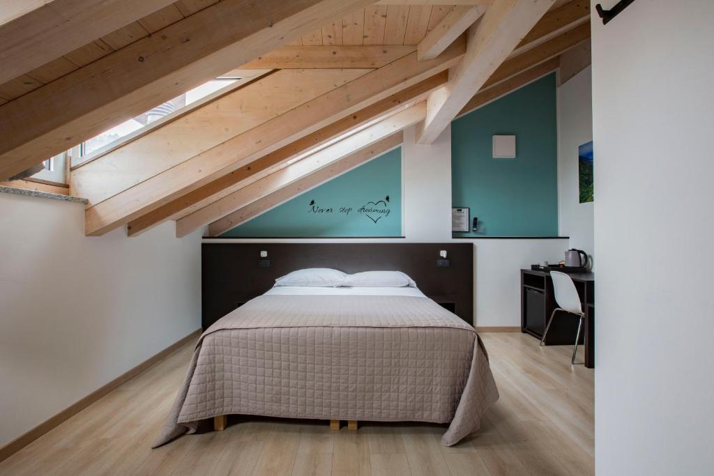 una camera da letto con un grande letto in mansarda di Il B&B di Piazza Motta ad Albese Con Cassano