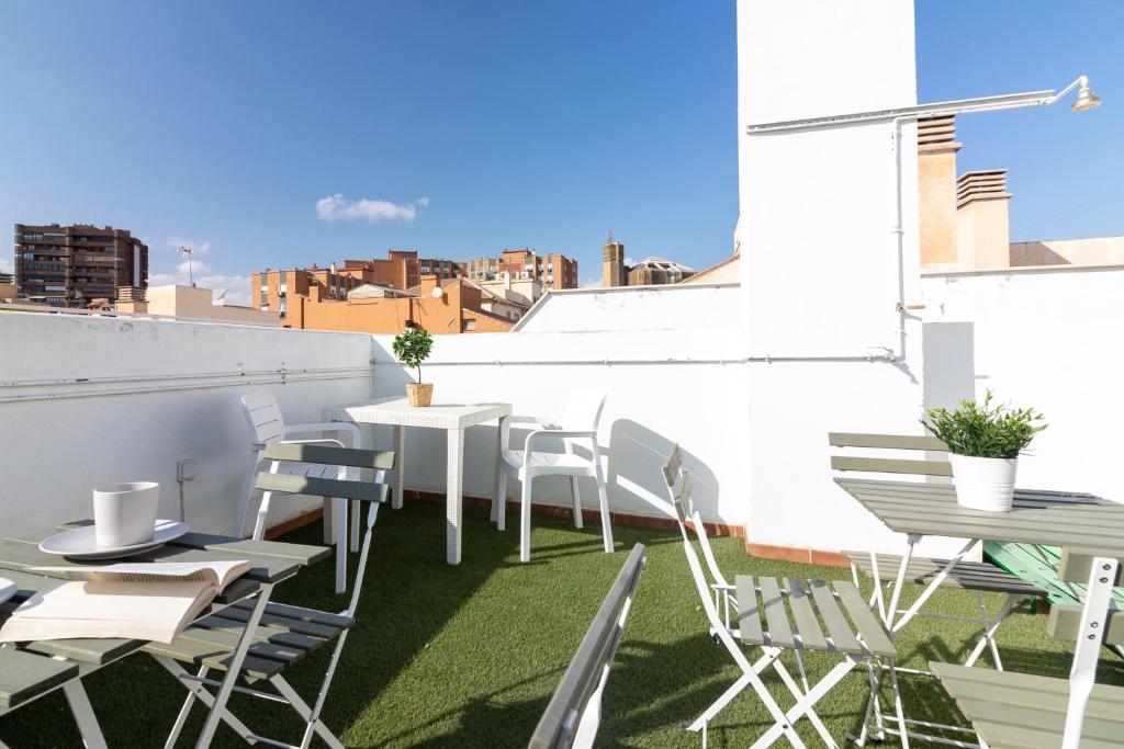 a patio with tables and chairs on a roof at Málaga Center Flat. Carmen City Center Roof-Terrace Boutique in Málaga