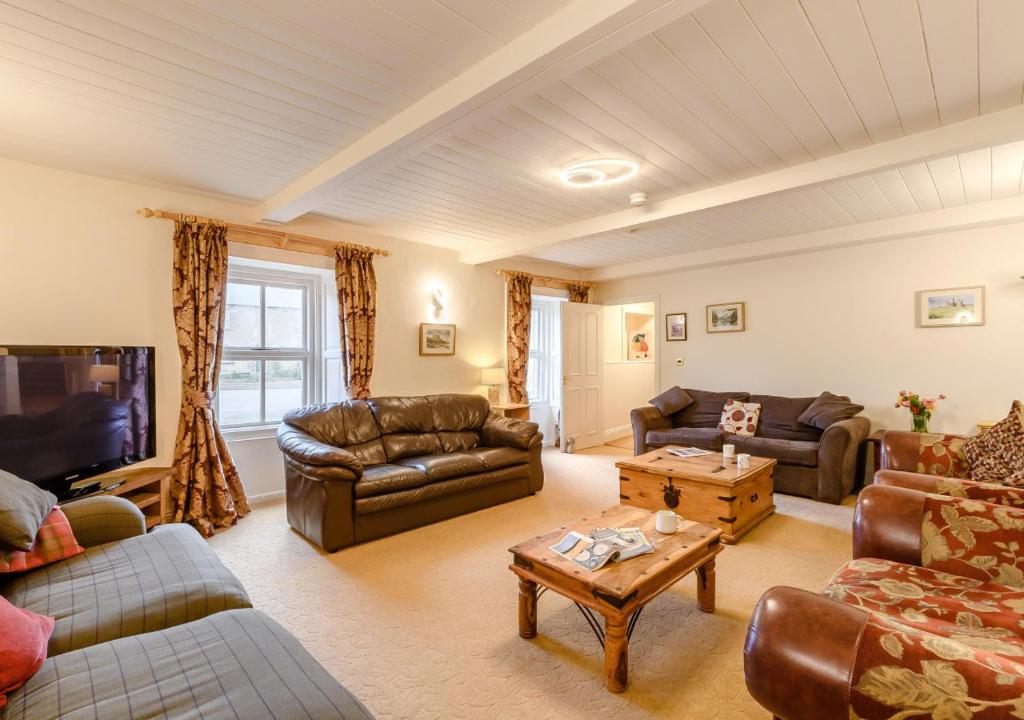 a living room with leather couches and a table at Vale View in Glanton