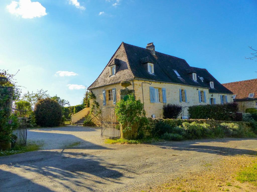 duży biały dom z czarnym dachem w obiekcie Gite Beynac w mieście Sainte-Mondane