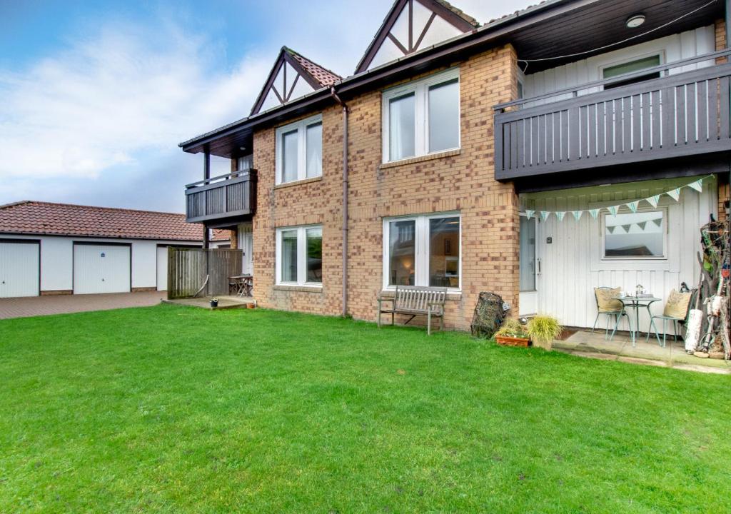 uma casa com um relvado em frente em Dunes Reach 3 Dunes Court em Beadnell