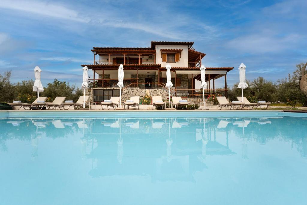 a villa with a swimming pool in front of a house at Kalisun Pool House by Georgalas in Nea Kalikratia