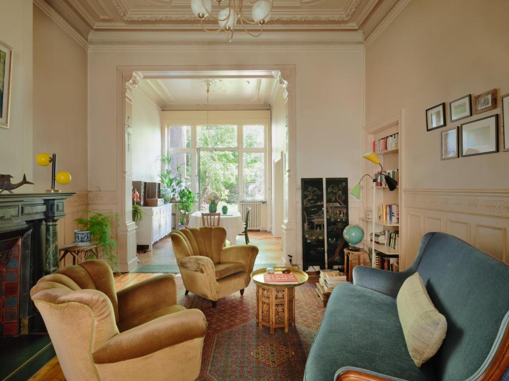 a living room with couches and chairs and a fireplace at Charming and spacious house with leafy private garden close to historical center of Brussels in Brussels