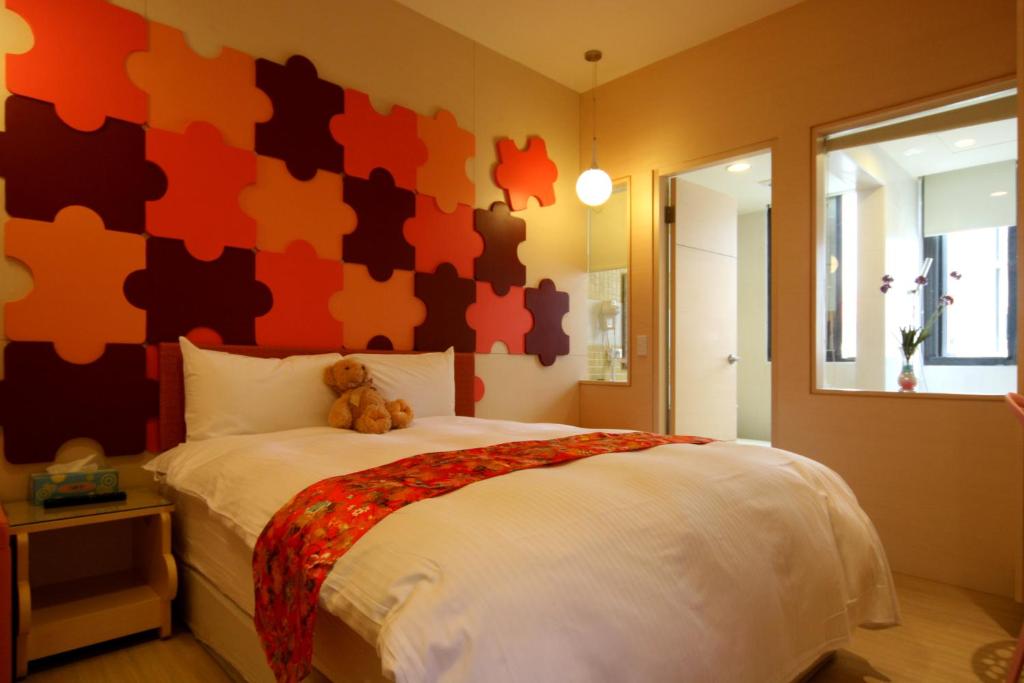 Un dormitorio con una cama grande con un osito de peluche. en Tanhui Modern Hotel, en Yuchi