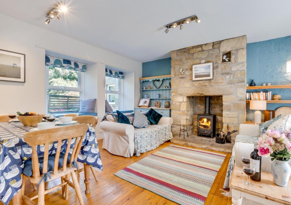 a living room with a stone fireplace at Old Mill Branton in Glanton