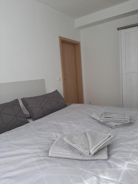 Una cama blanca con dos toallas encima. en Jaekels Ferienwohnung en Görlitz
