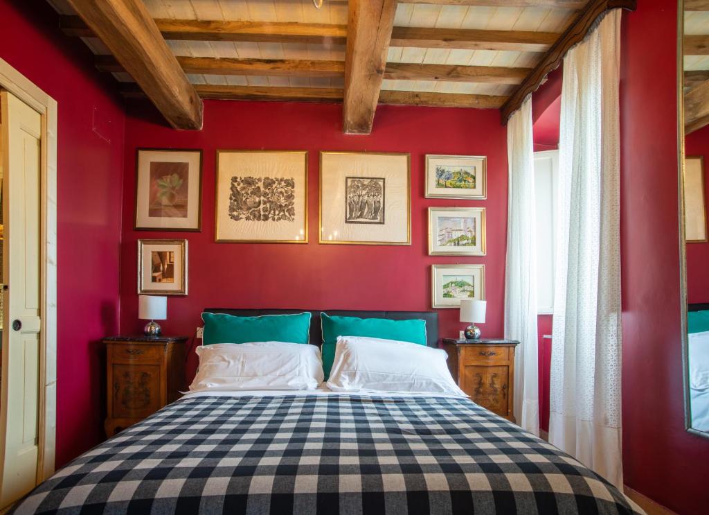 ein Schlafzimmer mit einem Bett in einer roten Wand in der Unterkunft La Viola di Assisi in Assisi