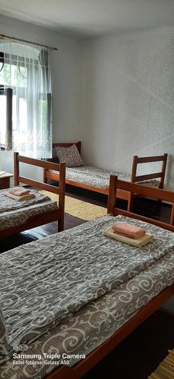 a room with two beds and a table and a window at CycloCamp & Hostel in Skorenovac