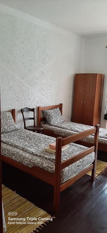 a bedroom with two beds and a wooden cabinet at CycloCamp & Hostel in Skorenovac