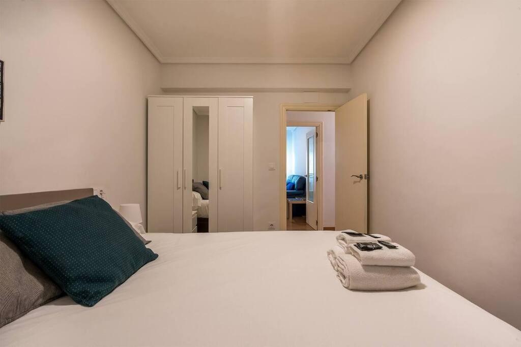 a bedroom with a white bed with a phone on it at Apartamento en la Ribera Bilbao Anfitrión Verónica in Bilbao