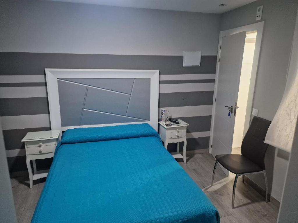 科爾多瓦的住宿－Viana Rooms Córdoba，一间小卧室,配有蓝色的床和椅子