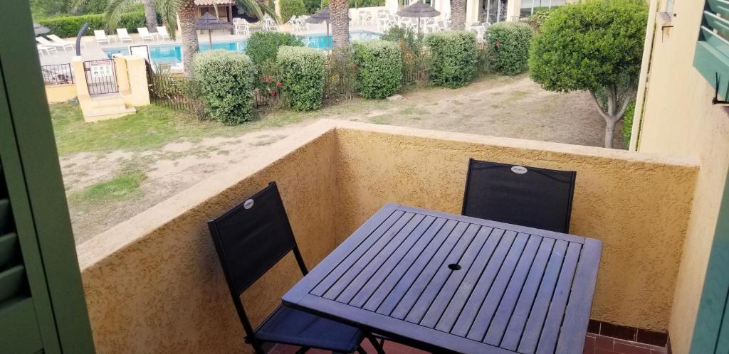 een blauwe tafel en 2 stoelen op een balkon bij Studio dans résidence avec piscine in Calvi