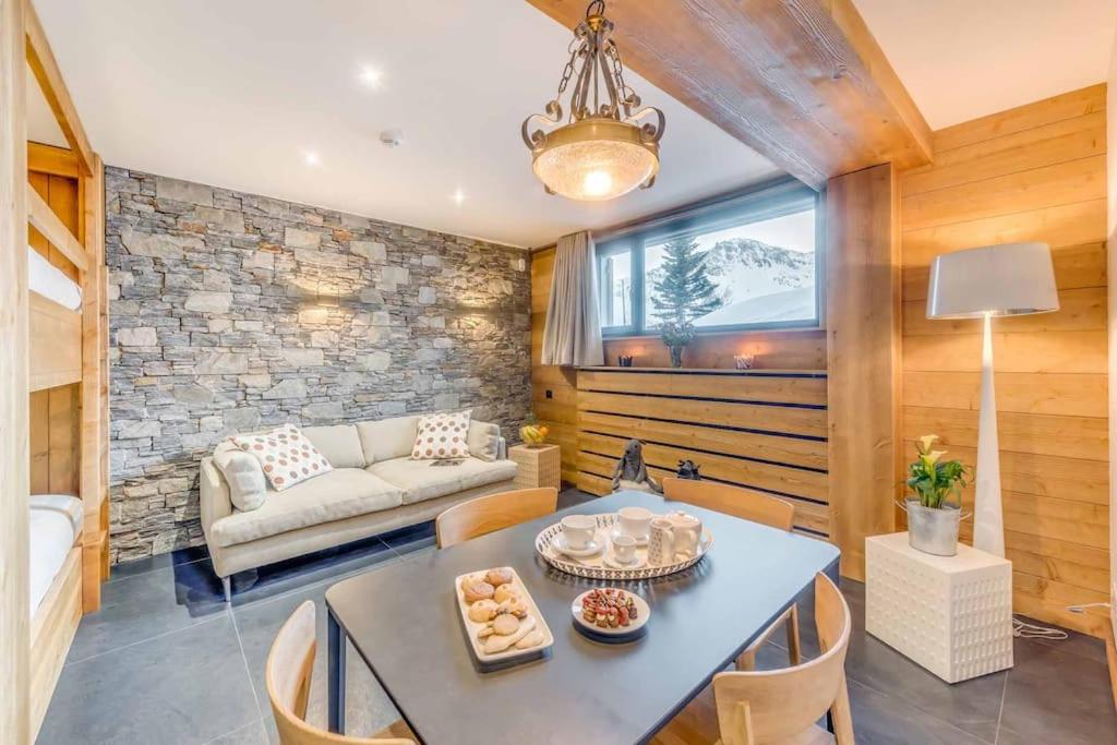 una sala de estar con una mesa y un sofá en Cosy apartment 2 - 6 persons, en Tignes