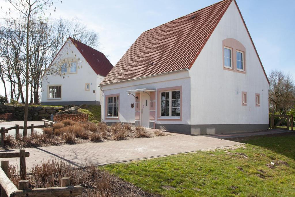 ein weißes Haus mit braunem Dach in der Unterkunft Haus Willy Bad Bentheim in Bad Bentheim