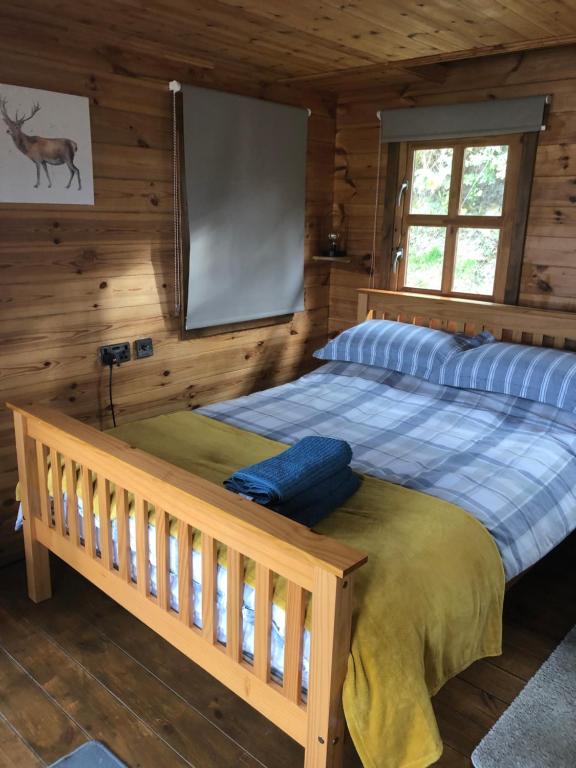 a bedroom with a large bed in a cabin at Bryn Fach Log Cabin in Merthyr Cynog