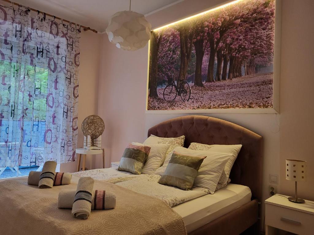 una camera da letto con un letto e un dipinto sul muro di Grand Apartman San with garage a Sarajevo