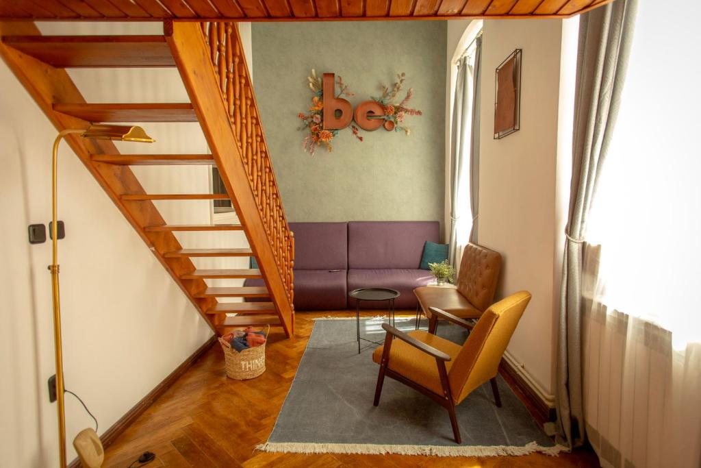 ブラショヴにあるBe Roomsのリビングルーム(紫色のソファ付きの階段あり)