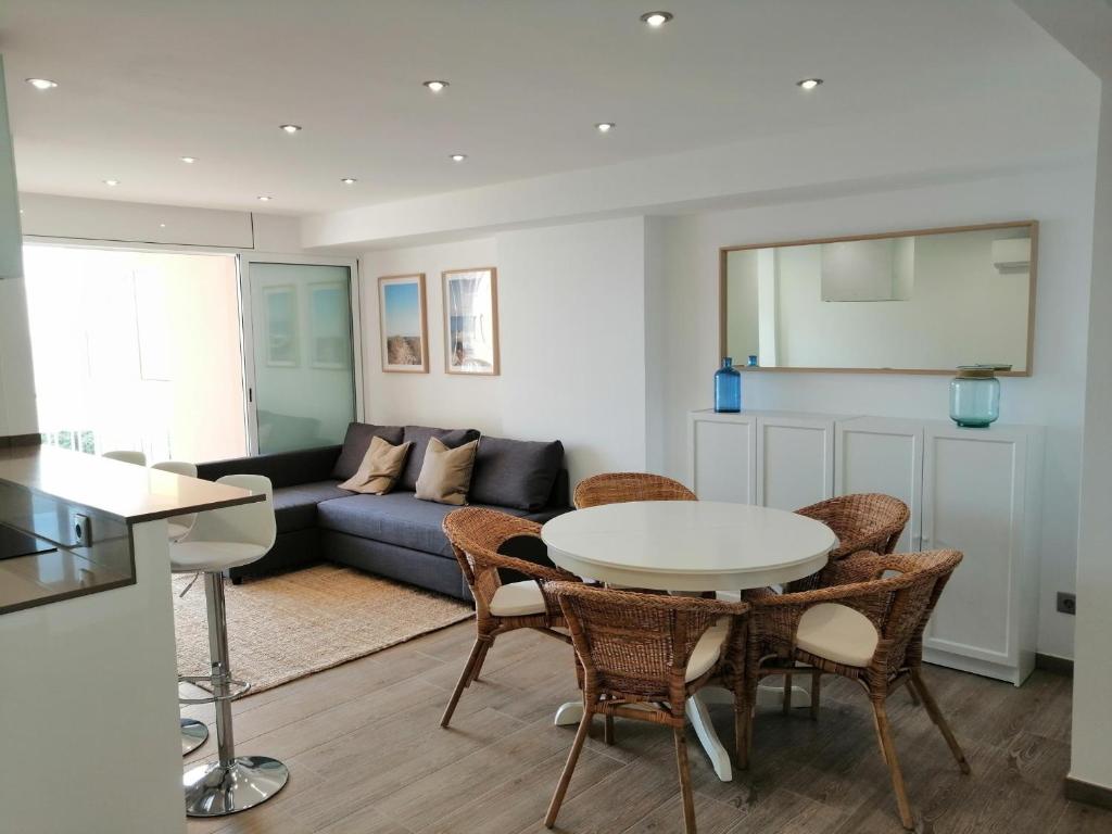 マルグラット・デ・マルにあるRECONNECTAR Malgrat de Mar Garbí Iのテーブルと椅子とソファのあるリビングルーム