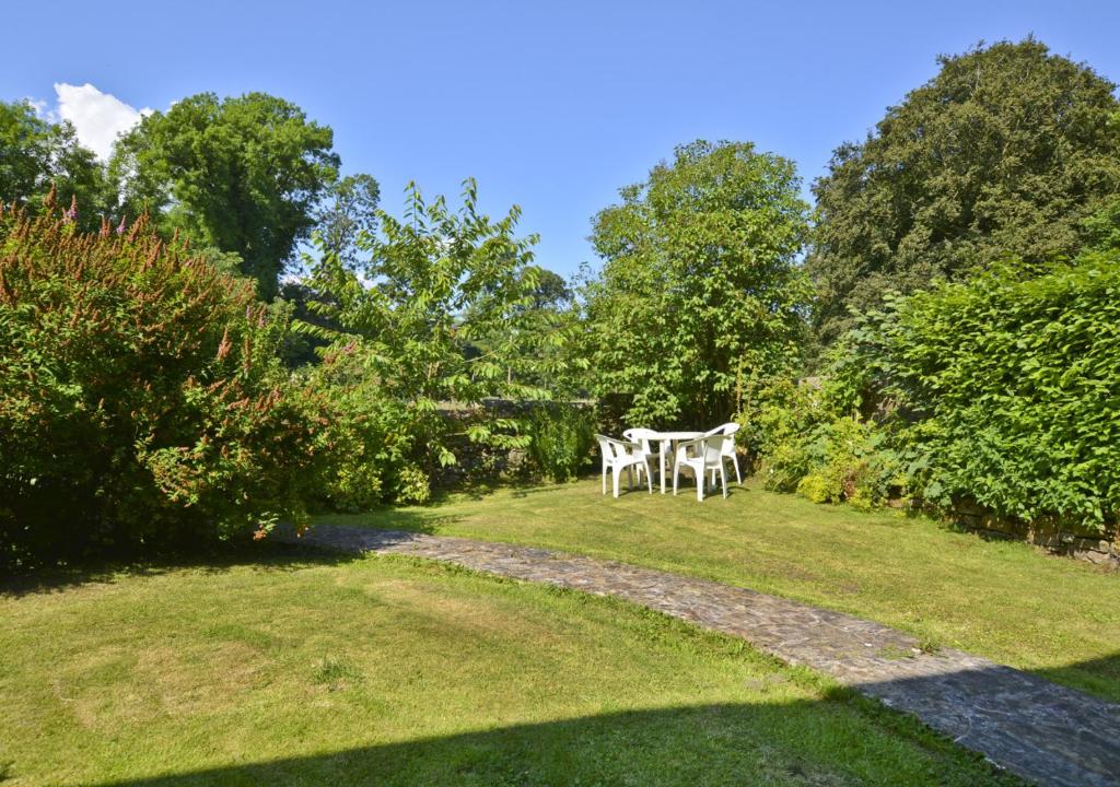 una mesa y sillas en un patio con árboles en Holmhead Cottage, en Greenhead