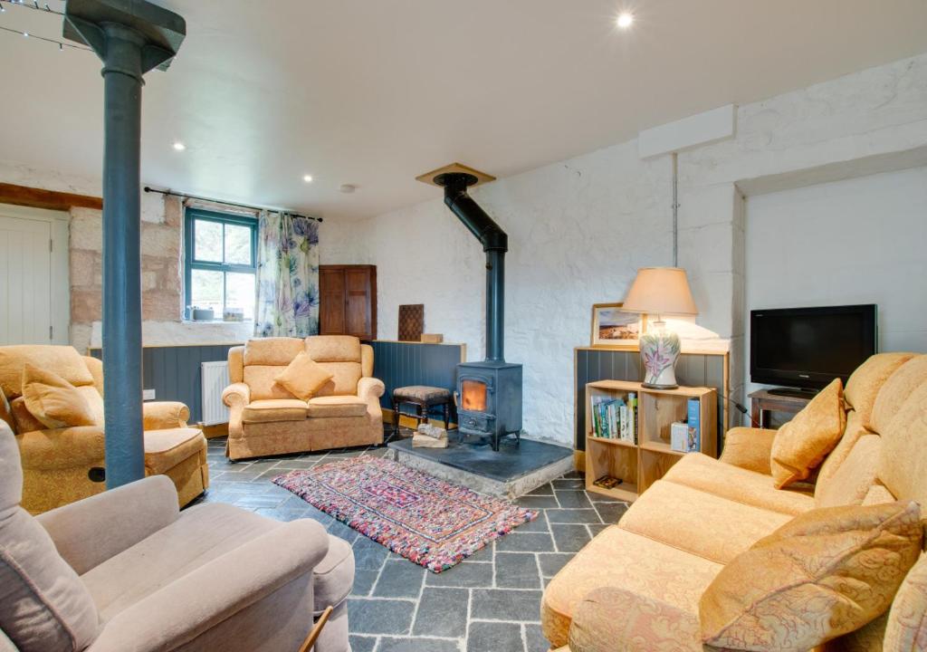 a living room with couches and a fire place at Little Dod Barn in Ilderton