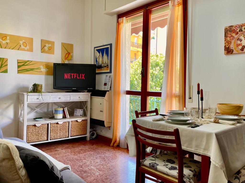 a living room with a table and a television at Relax a 800 mt dal Mare - Free Parking, A/C e WiFi in Pietra Ligure