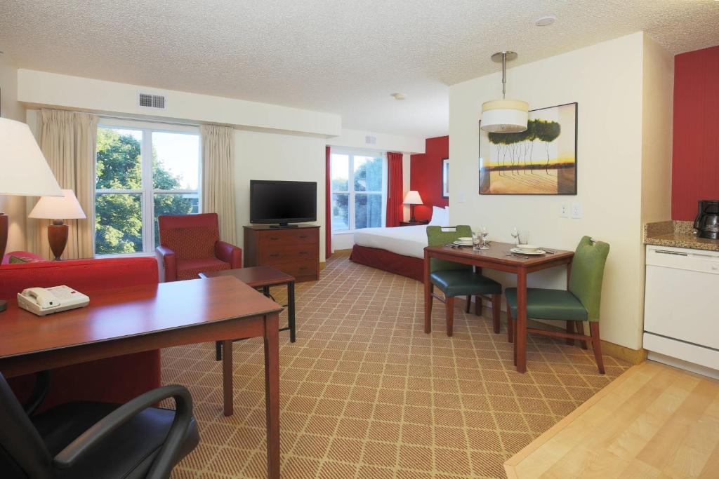 een hotelkamer met een bed en een tafel en stoelen bij Residence Inn by Marriott Flint Grand Blanc in Flint