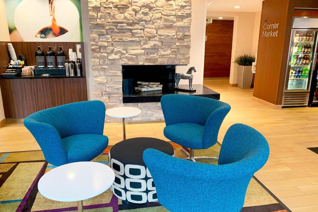 vestíbulo con sillas azules y chimenea en Fairfield Inn & Suites by Marriott Denver Tech Center/ South en Highlands Ranch