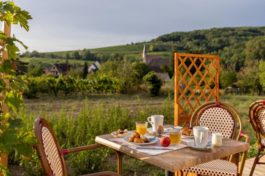 a wooden table with food and drinks on it at Hôtel Restaurant Le Kastelberg, The Originals Boutique in Andlau