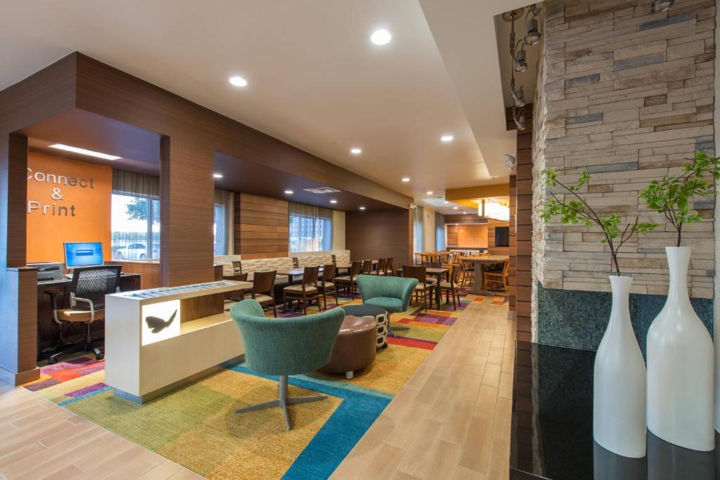 a lobby of a restaurant with chairs and tables at Fairfield Inn & Suites Dallas Lewisville in Lewisville