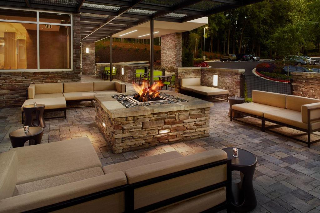 a fire pit in a patio with couches and a fireplace at SpringHill Suites by Marriott Atlanta Northwest in Atlanta