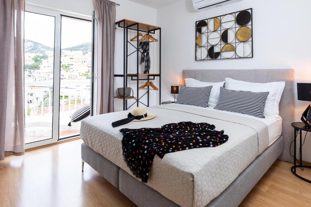 um quarto com uma cama grande e uma janela grande em Apartments Sunny Elza em Hvar