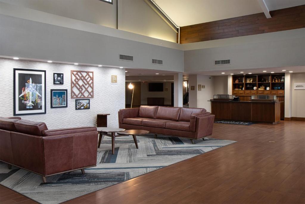 a lobby with two leather couches and a table at Four Points by Sheraton Allentown Lehigh Valley in Allentown