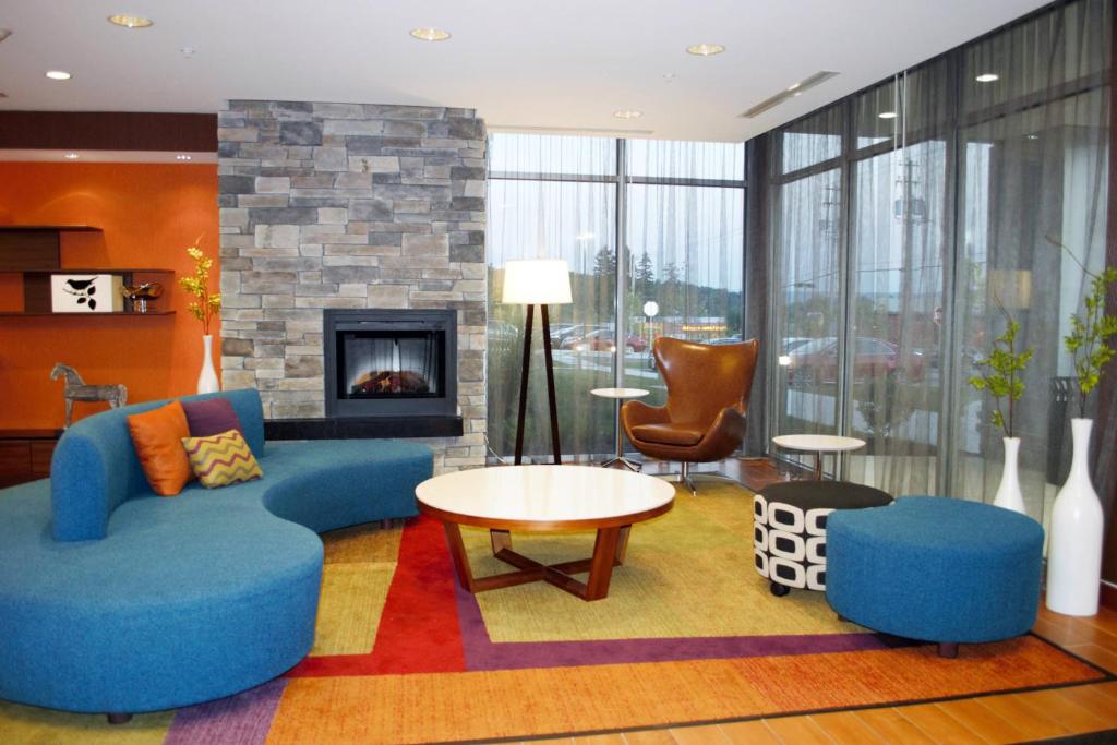 a living room with blue furniture and a fireplace at Fairfield Inn & Suites by Marriott Stroudsburg Bartonsville/Poconos in Stroudsburg