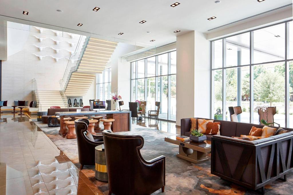 a lobby with chairs and tables and windows at Renaissance Dallas at Plano Legacy West Hotel in Plano