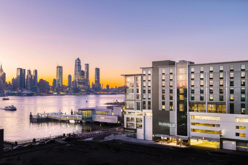 a building next to a body of water with a city at Residence Inn by Marriott Weehawken in Weehawken