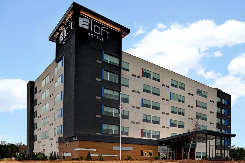 un edificio de oficinas con un cartel de hotel en él en Aloft Mooresville en Mooresville