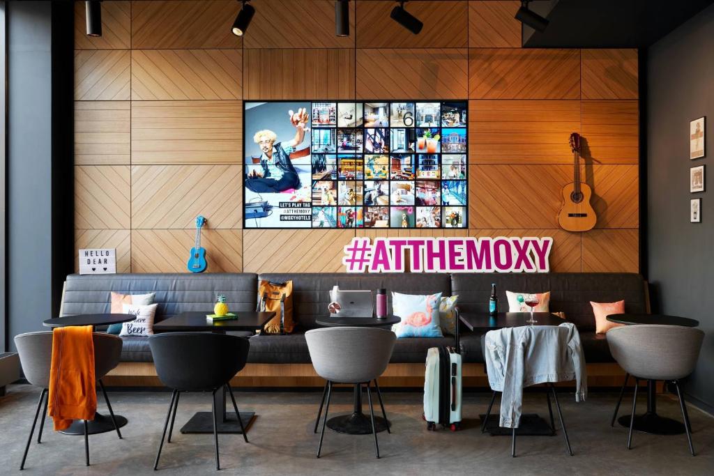 un ristorante con divano e TV a parete di Moxy Edinburgh Fountainbridge a Edimburgo
