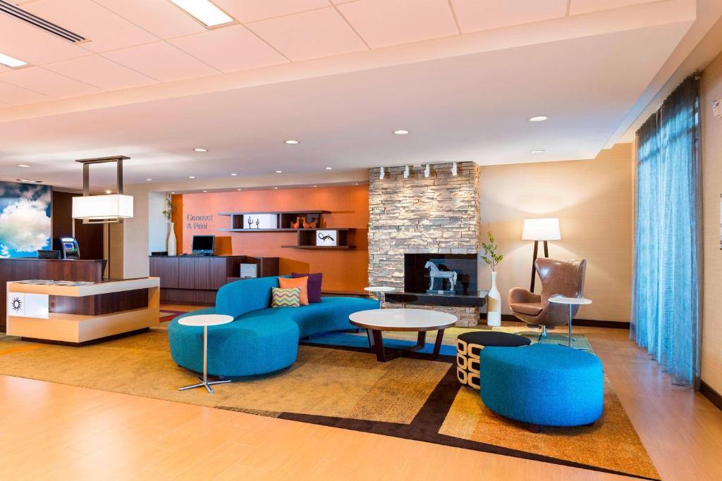 a lobby with blue furniture and a fireplace at Fairfield by Marriott Inn & Suites Palm Desert Coachella Valley in Palm Desert
