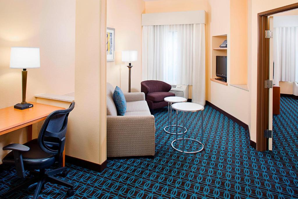 um quarto de hotel com um sofá, uma cadeira e uma secretária em Fairfield Inn & Suites by Marriott Lafayette South em Lafayette