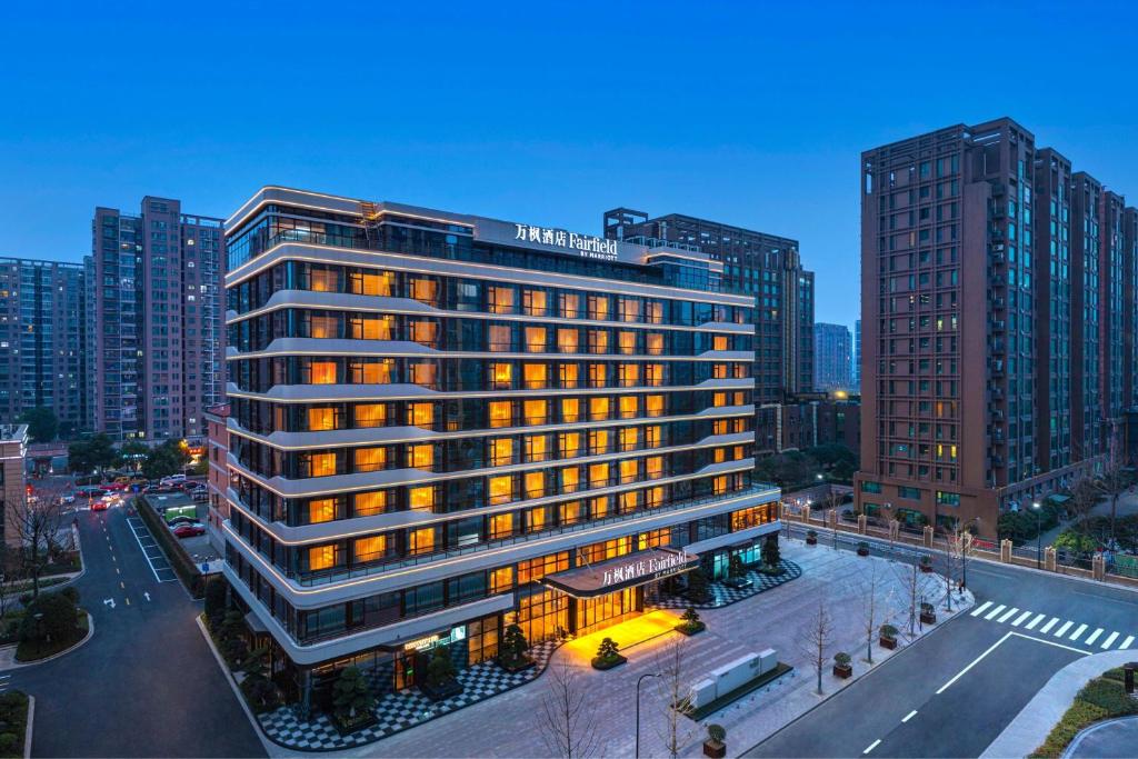un grand bâtiment éclairé dans une ville dans l'établissement Fairfield by Marriott Hangzhou Xiaoshan, à Hangzhou