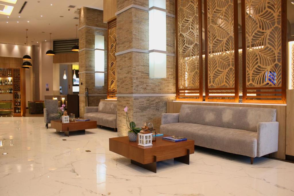 a lobby with couches and tables in a building at Courtyard by Marriott Guayaquil in Guayaquil