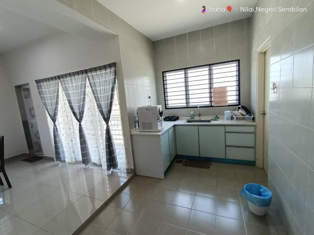 尼萊的住宿－Homestay Nilai D'Jati，厨房配有柜台、水槽和窗户